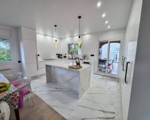 Laure nos contactó para transformar su vivienda ubicada en la zona de El Lladoner, Vallirana. El proyecto, ejecutado en octubre de 2024, buscaba modernizar el corazón del hogar mediante una transición fluida entre la zona de trabajo y el área social. 