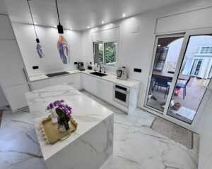 Laure nos contactó para transformar su vivienda ubicada en la zona de El Lladoner, Vallirana. El proyecto, ejecutado en octubre de 2024, buscaba modernizar el corazón del hogar mediante una transición fluida entre la zona de trabajo y el área social. 