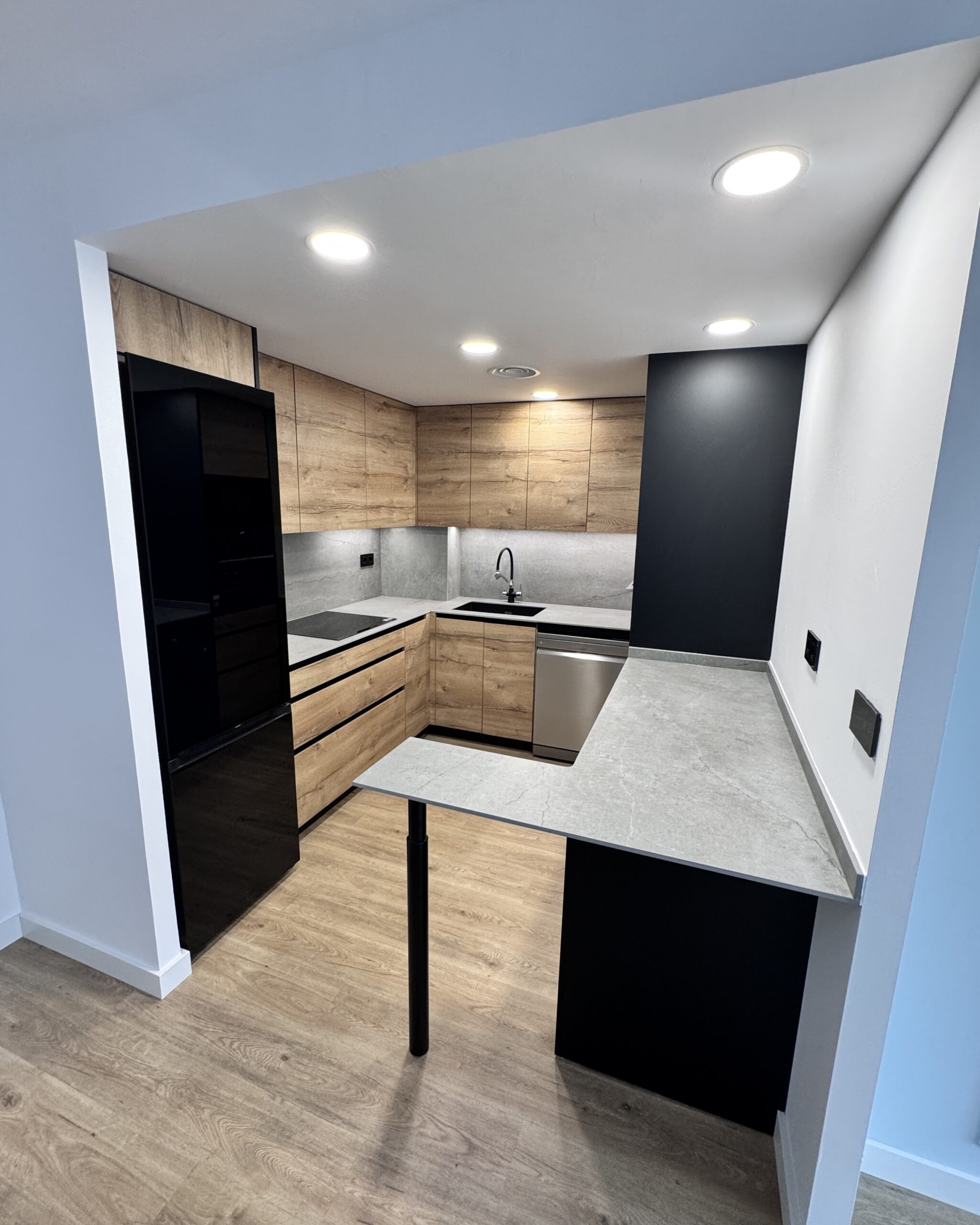 Descubre cómo transformamos una vivienda unifamiliar en Sant Feliu mediante una reforma integral que combina aerotermia, diseño de vanguardia con acabados en roble y materiales de alta gama como Dekton.