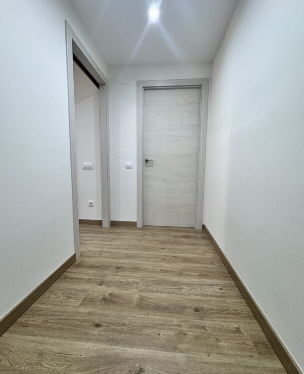 Proyecto de reforma en Pallejà realizado por Grup Innova: iluminación, techo de pladur, suelo laminado, puertas nórdicas y pintura para un piso más luminoso.