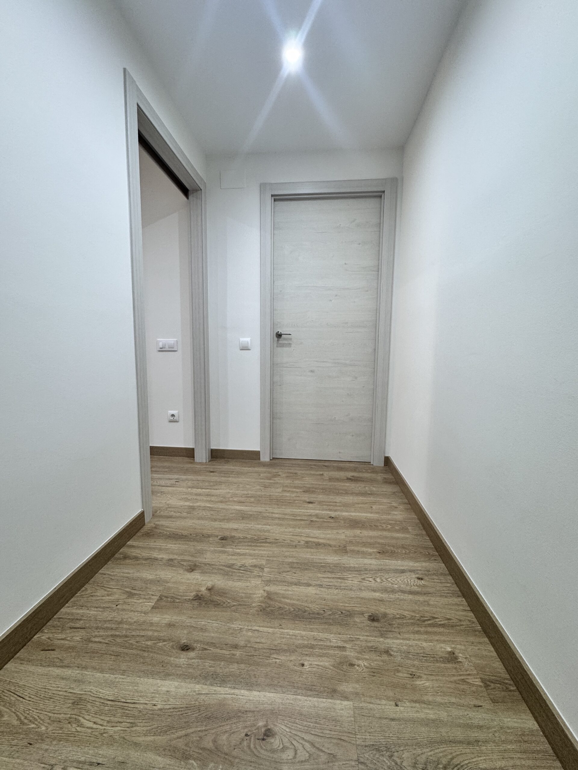 Proyecto de reforma en Pallejà realizado por Grup Innova: iluminación, techo de pladur, suelo laminado, puertas nórdicas y pintura para un piso más luminoso.