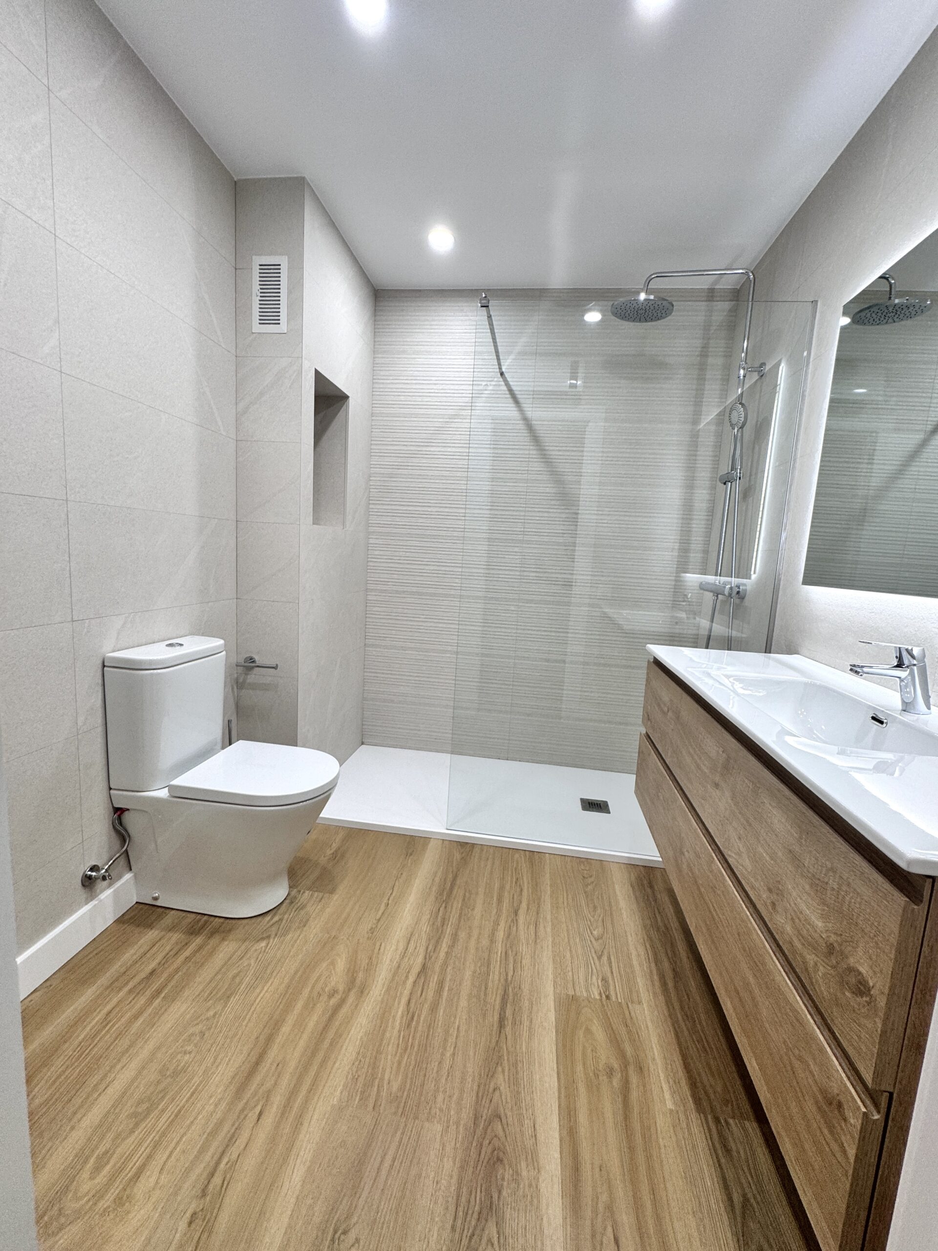 Descubre cómo transformamos un baño principal y un aseo en Barcelona para nuestra cliente Mª Ángeles. Una reforma integral con plato de ducha, suelo vinílico SPC y soluciones de almacenaje a medida.