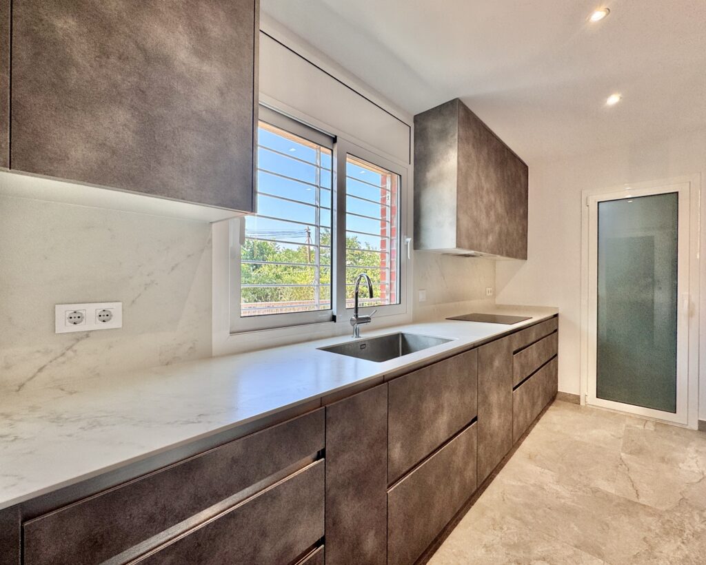 Descubre esta reforma de cocina en Caldes de Montbui con mobiliario a medida, suelo porcelánico Pamesa, encimera Dekton y acabados de alta calidad.